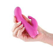 A pink silicone vibrator with a rabbit ear shape held in a hand.