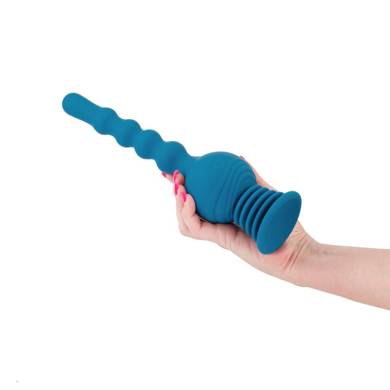 A teal, ribbed massager with a flared base is held by a hand.