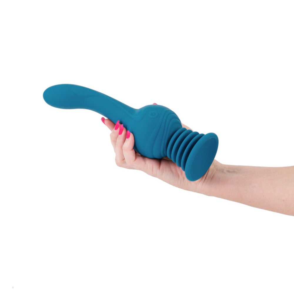 Teal rotating rechargeable remote massager held in a hand.