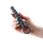 A hand holds a grey vibrating wand with a finger ring.