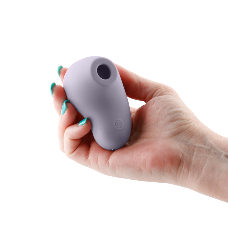 A purple pulsating air technology stimulator held in a hand.