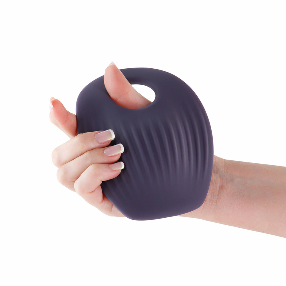 Gray hands-free vibrating grinding pad held in a hand.
