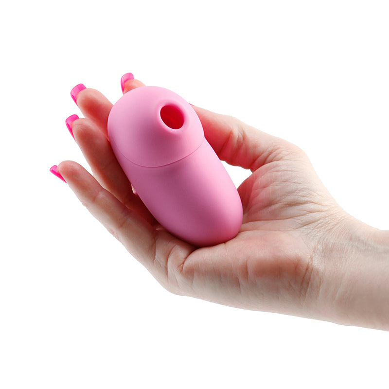 A pink silicone clitoral stimulator held in a hand.