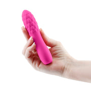 Pink textured silicone massager held in a hand.