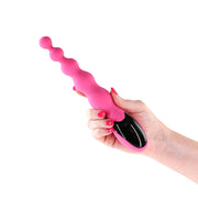 Pink beaded vibrator with a black digital control panel held in a hand.