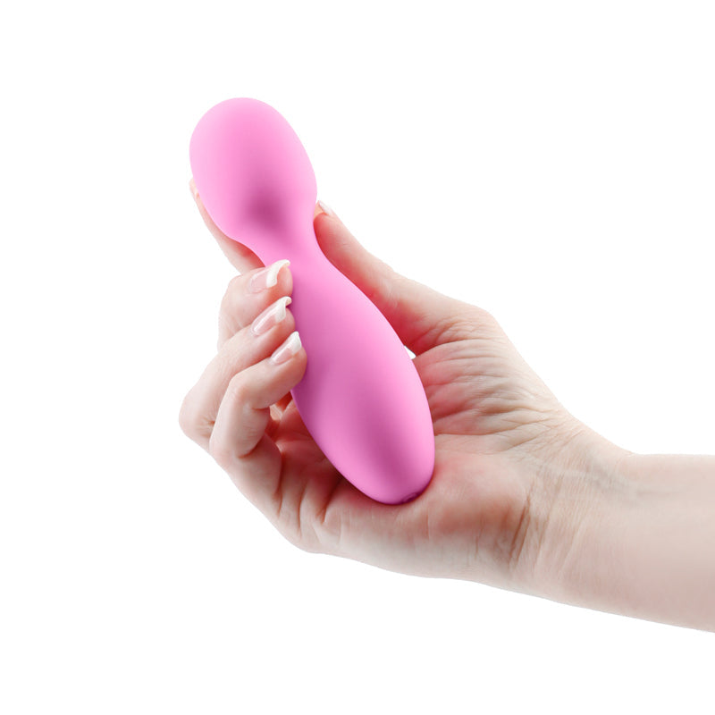 A pink silicone wand massager held in a hand.