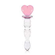 A clear glass toy with a pink heart-shaped top.