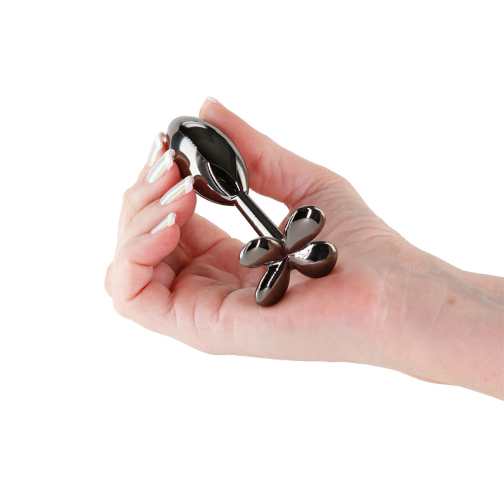 Gunmetal chrome clover anal plug held in a hand.