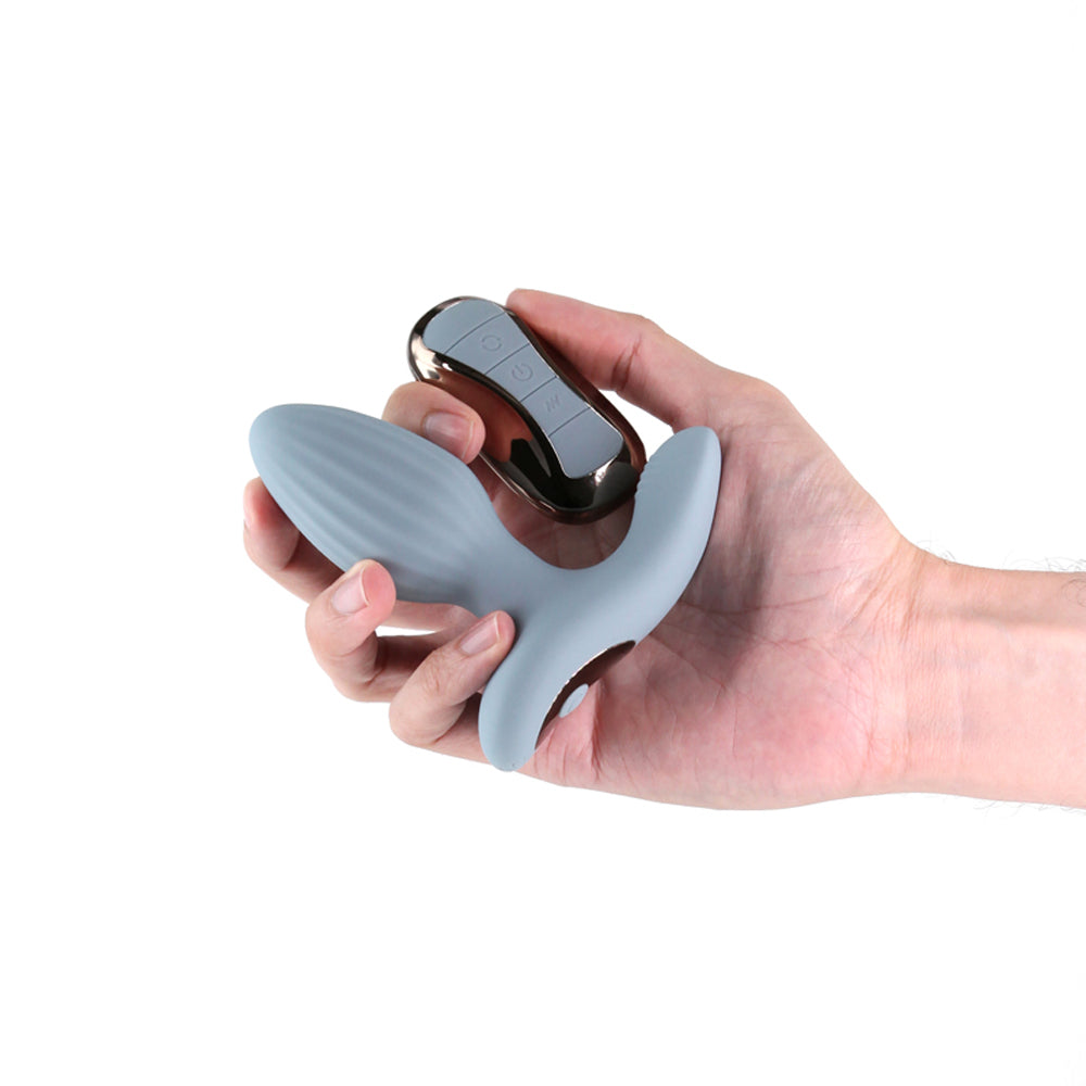 Gray rotating remote control anal plug held in a hand.