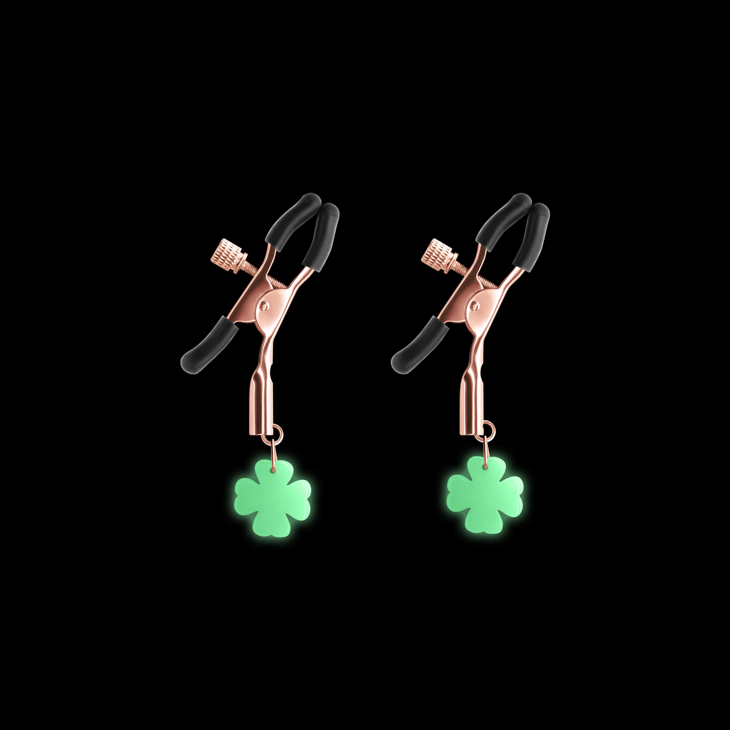 Adjustable rose gold nipple clamps with glow-in-the-dark clover charms.