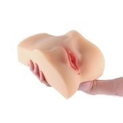 A realistic TPE stroker with a textured interior, held by a hand.