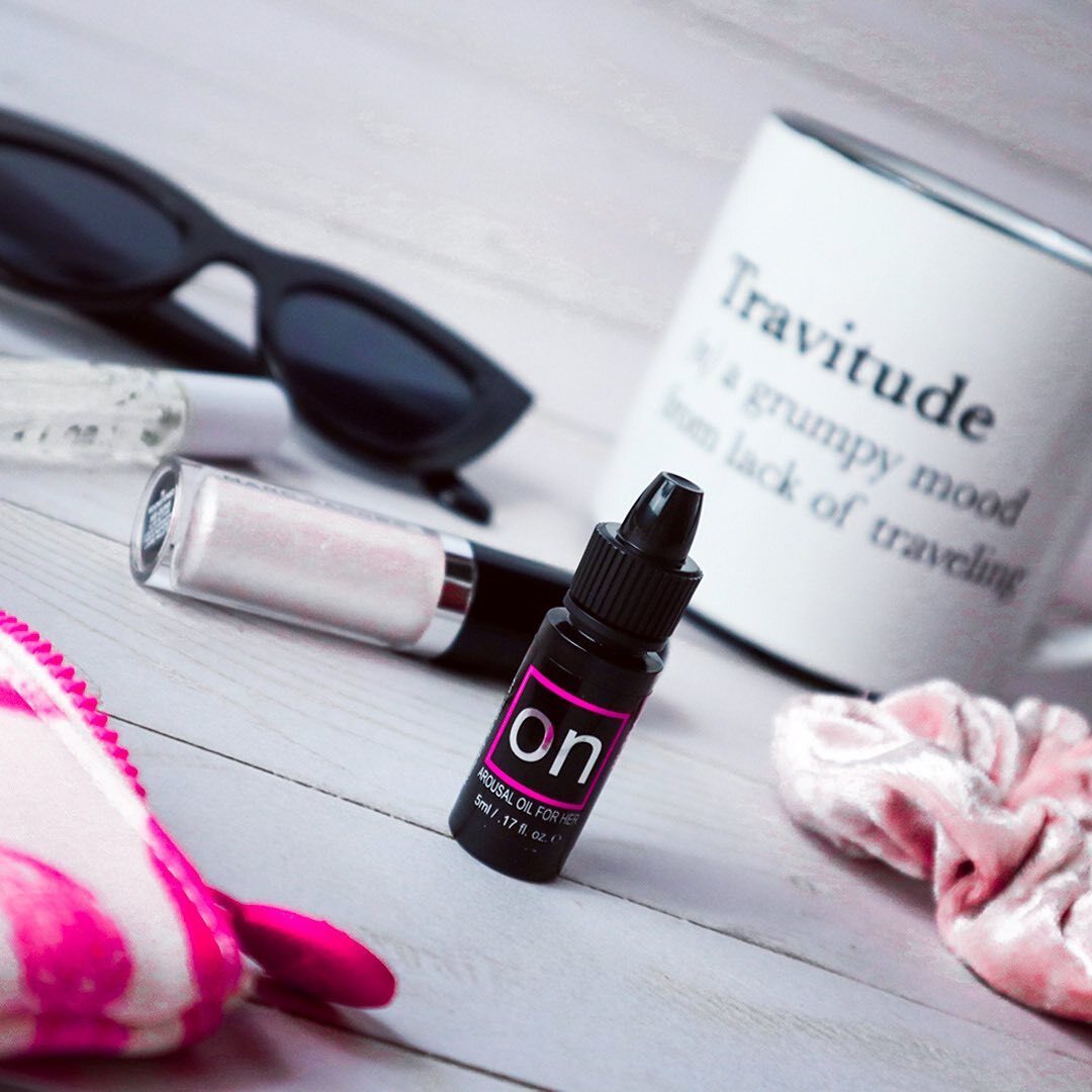 Arousal oil for her in a small black bottle with pink lettering.