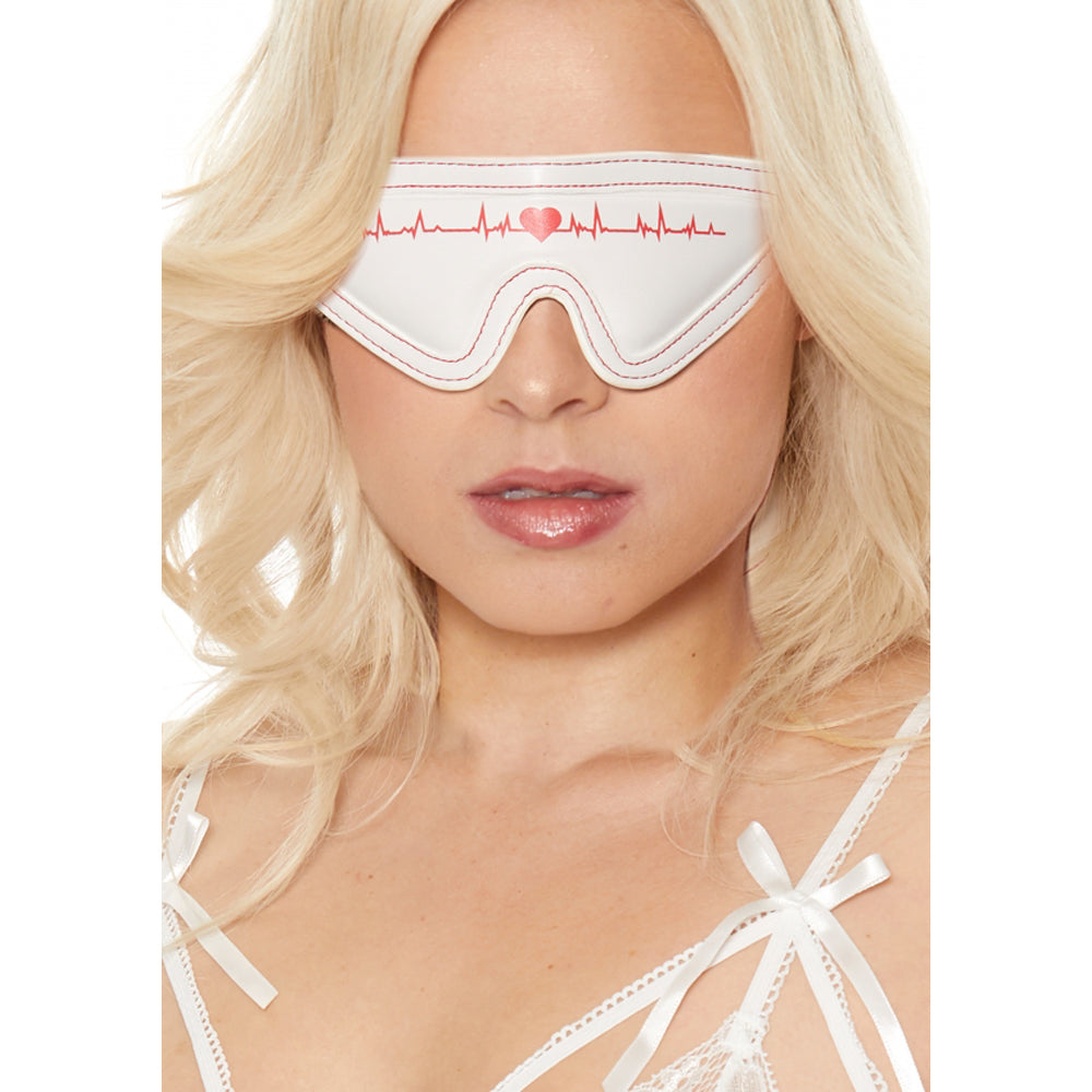 White eye mask with red stitching and a heartbeat design.