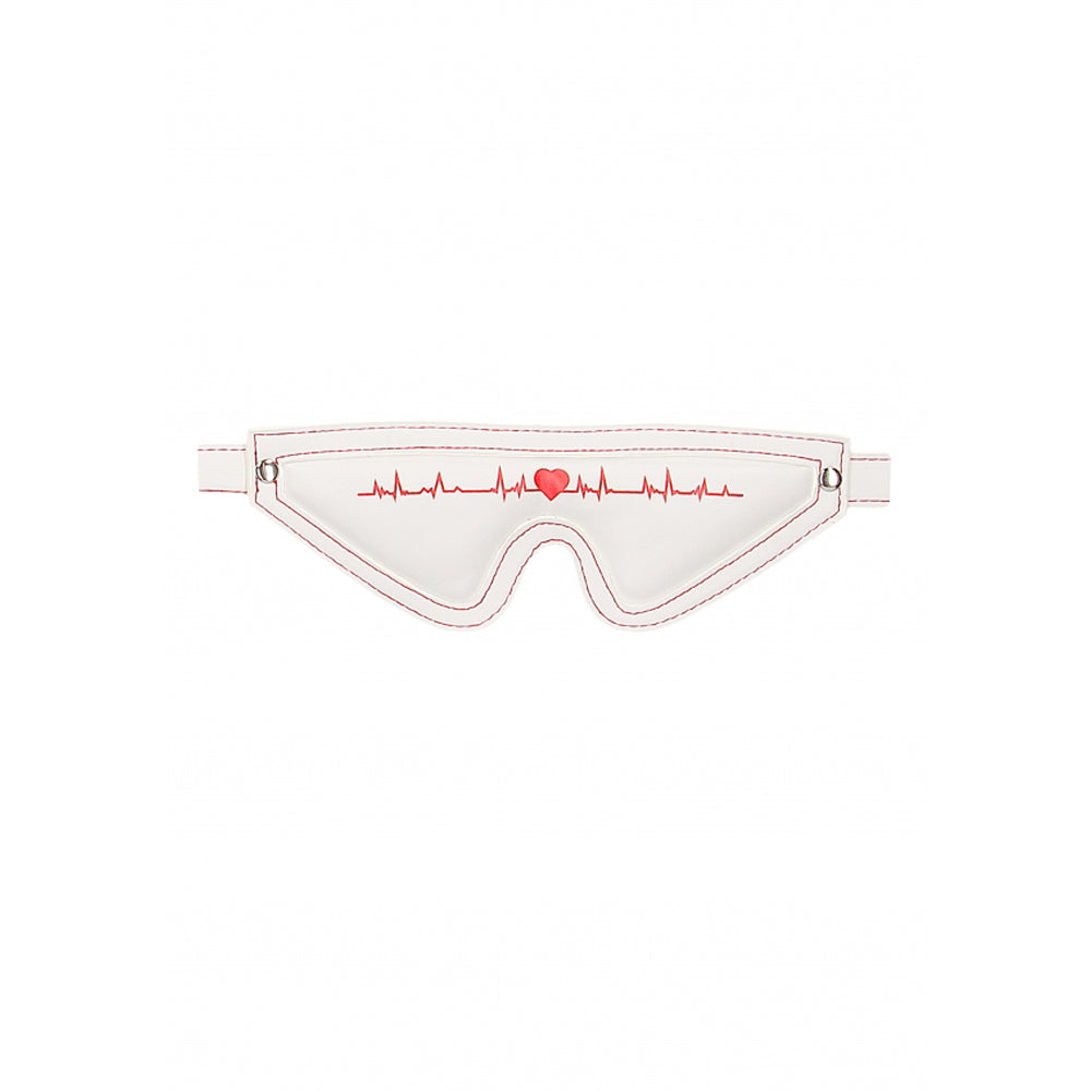 White eye mask with red stitching and a red heart on a heartbeat line.