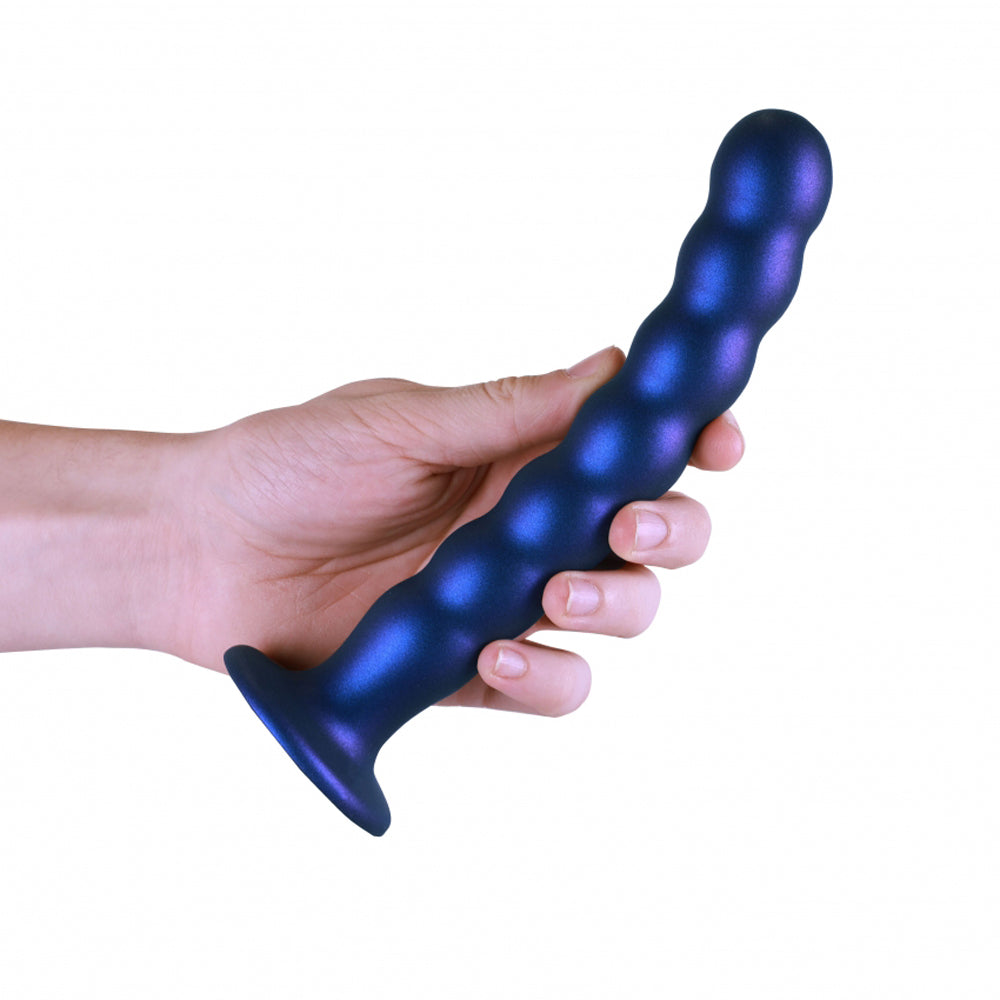 A hand holds a blue beaded silicone dildo with a flared base.