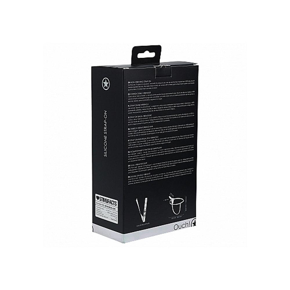 Adjustable silicone strap-on dildo set on a black box.