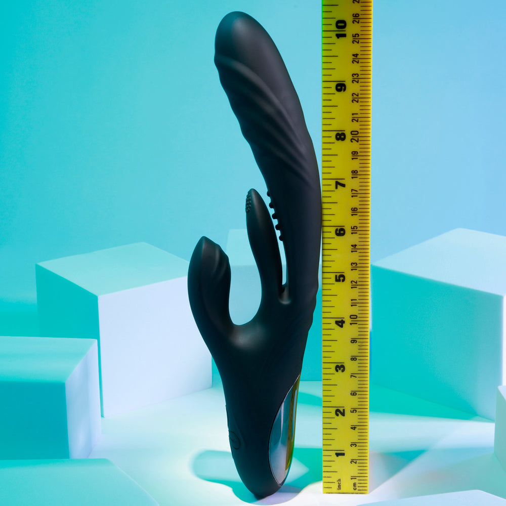 Black silicone vibrator with a ruler showing its length.