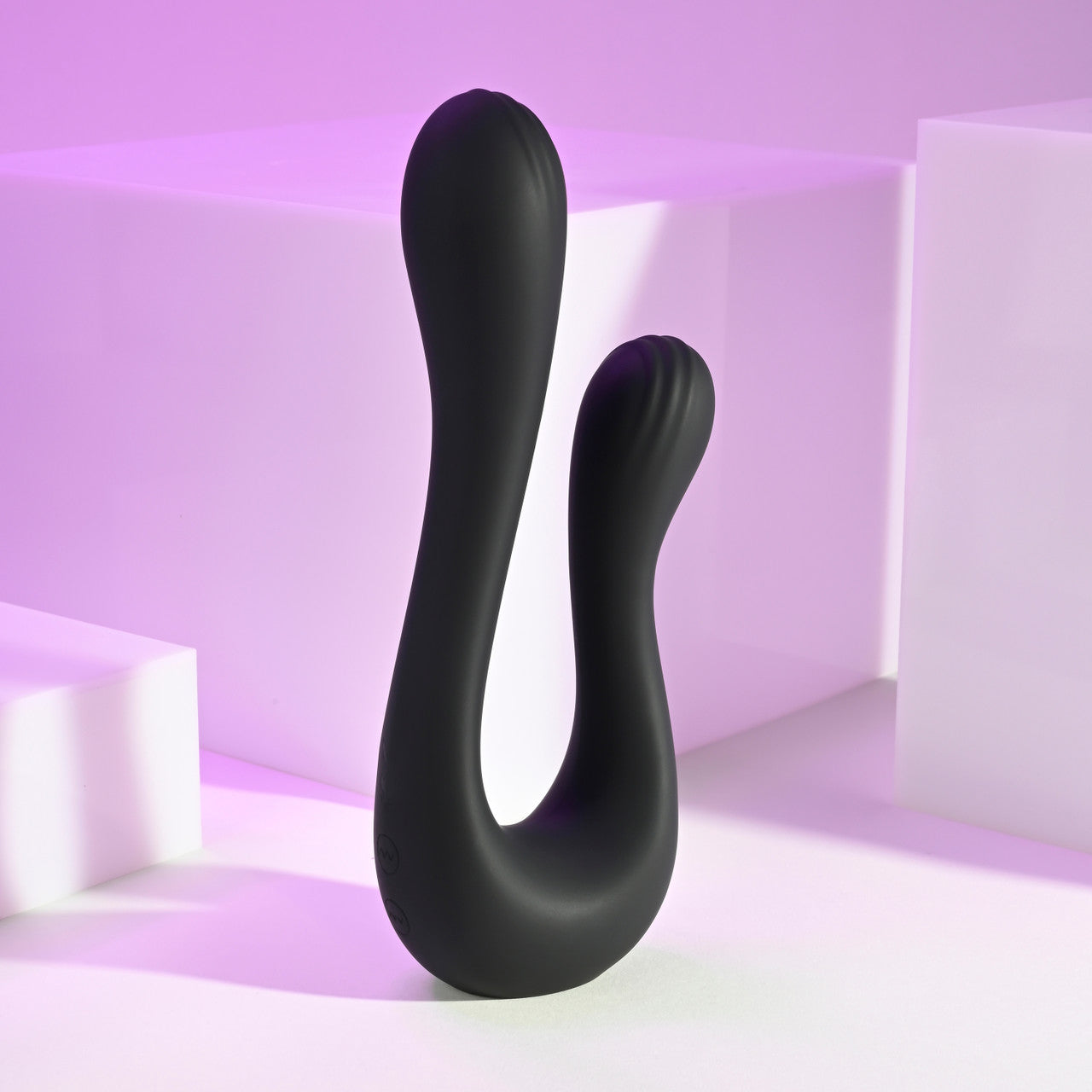 A black dual silicone vibrator with two curved shafts and textured heads.