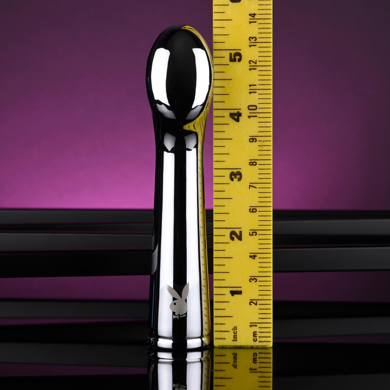 A silver Playboy vibrator is shown next to a yellow ruler.