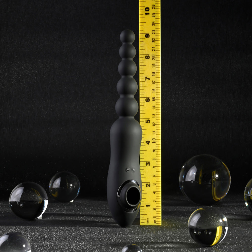 Black vibrating anal beads with clitoral suction and a ruler.