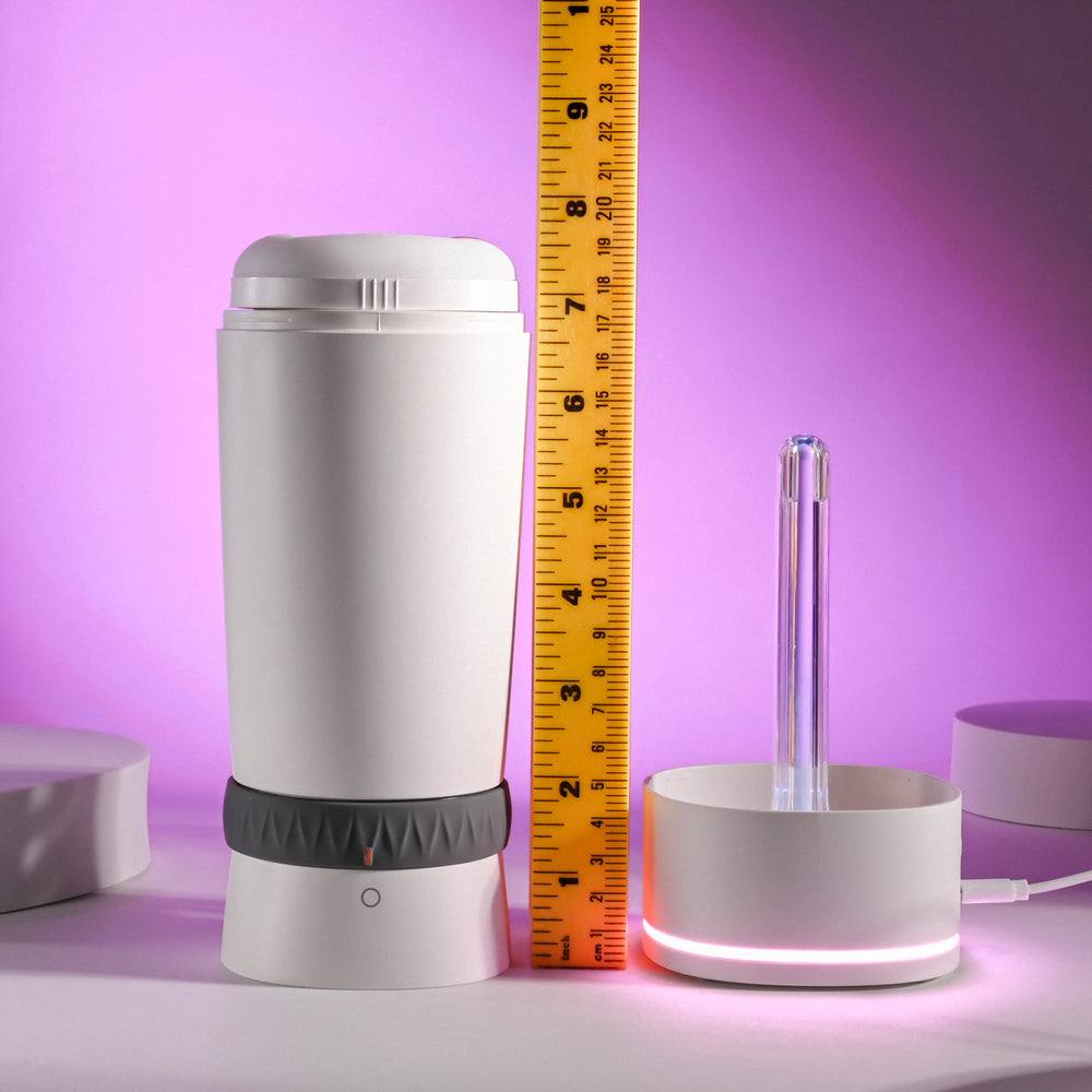 Playboy Heating Vibrating Stroker with UV Cleaner, white with grey band, next to a ruler.