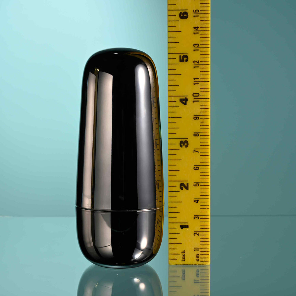 Black clitoral suction toy with a charging case shown next to a ruler.