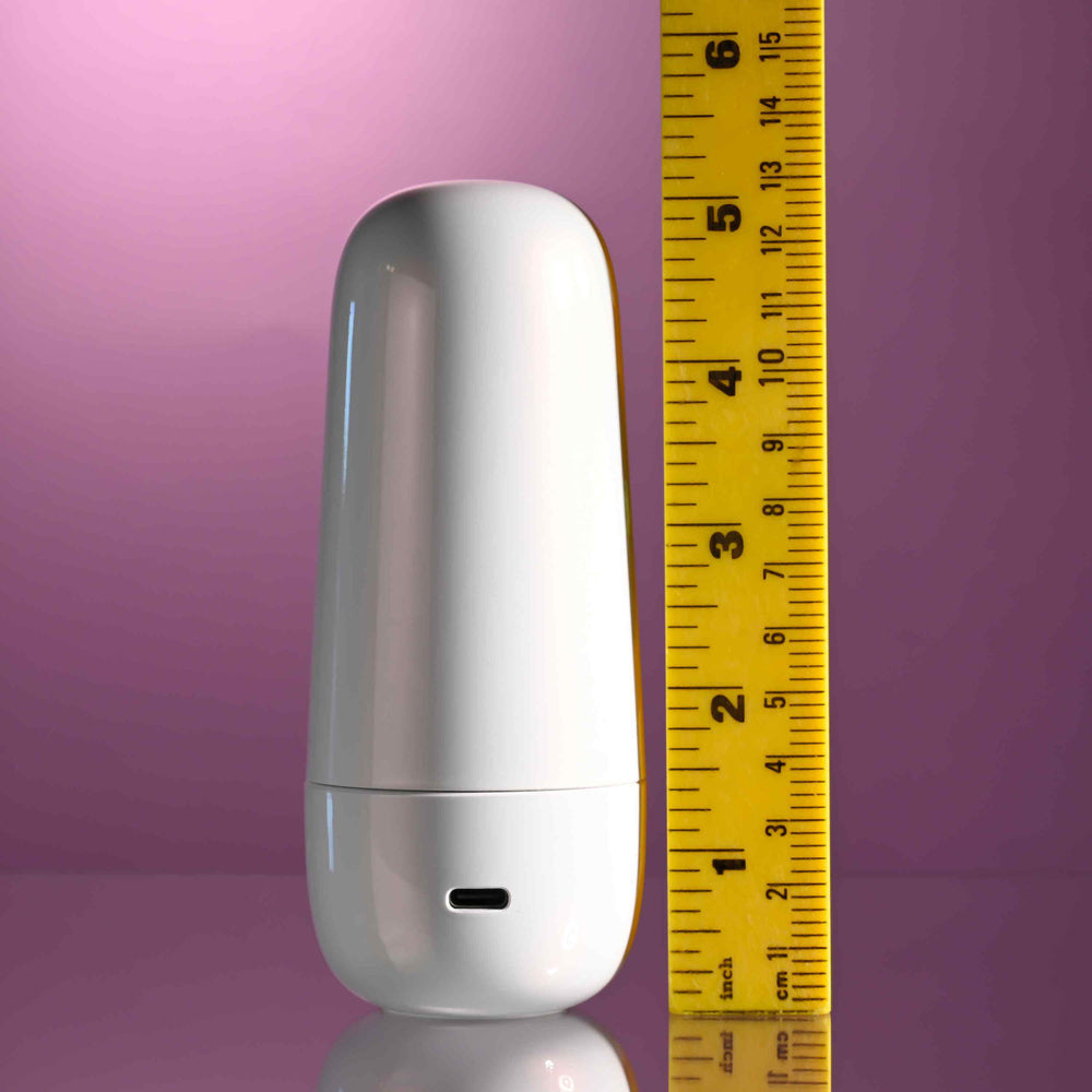 White silicone clitoral tapping toy next to a ruler.