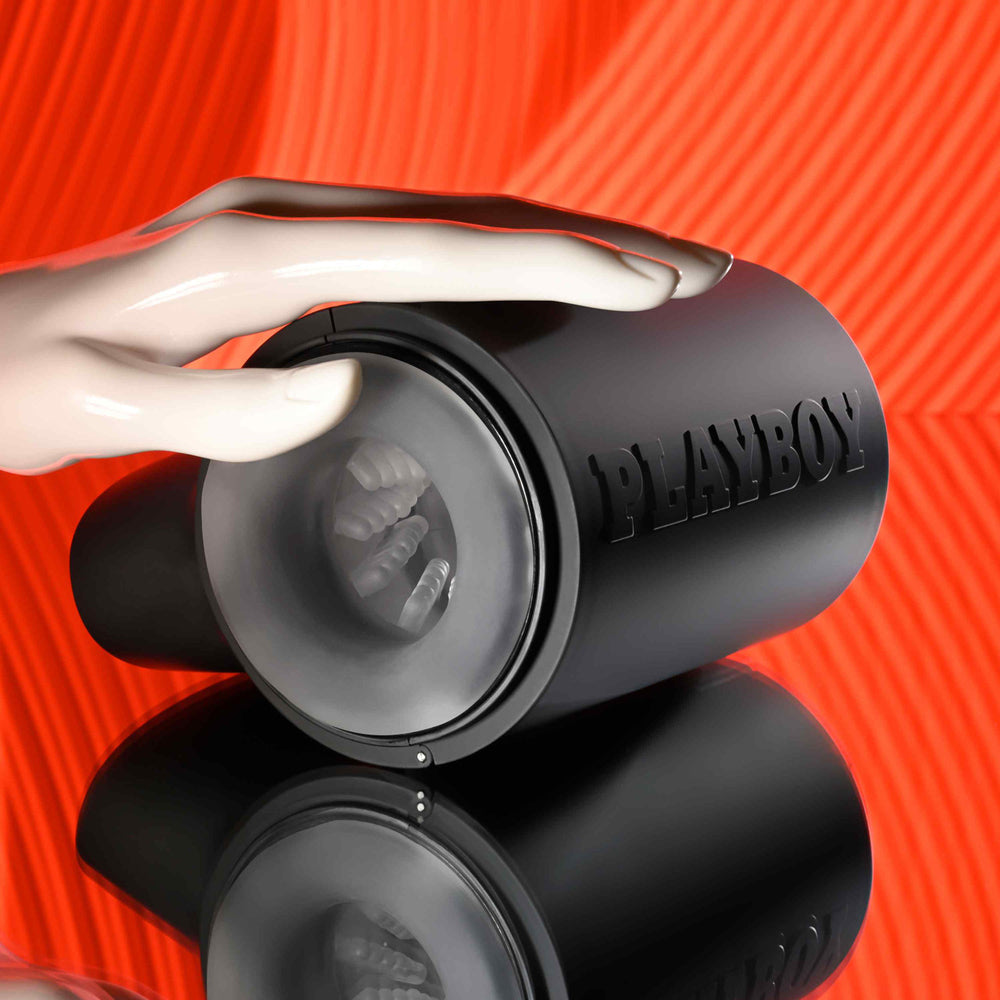 Black Playboy travel stroker with textured interior and a hand holding it.