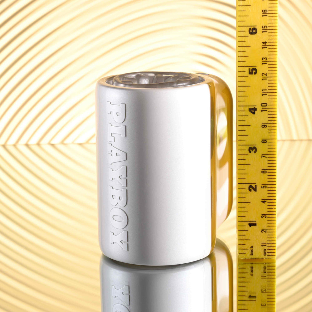 A white Playboy spinning male masturbator next to a ruler.