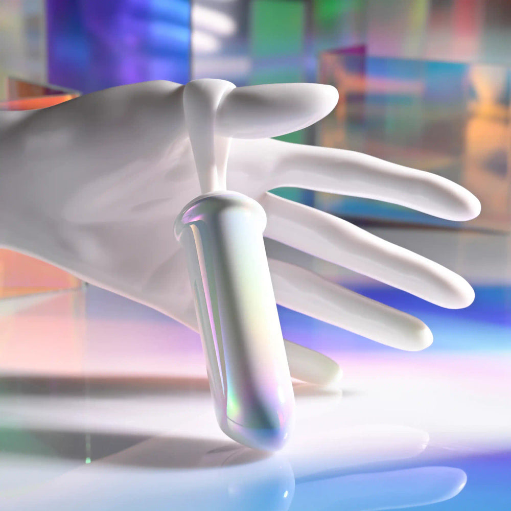 White silicone vibrator with iridescent finish held by a white hand.
