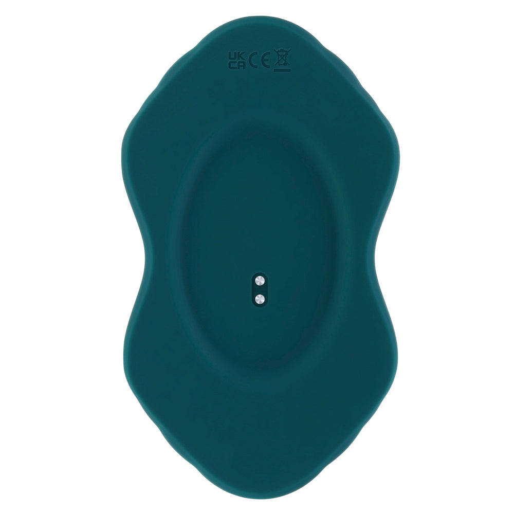 A teal silicone massager with charging pins and UK/CE markings.