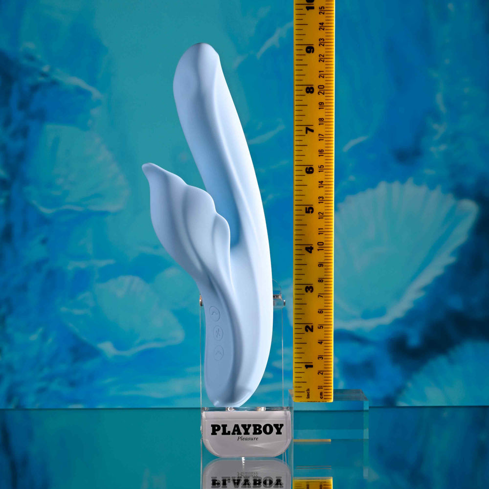 A light blue dual vibrator with a ruler for scale.