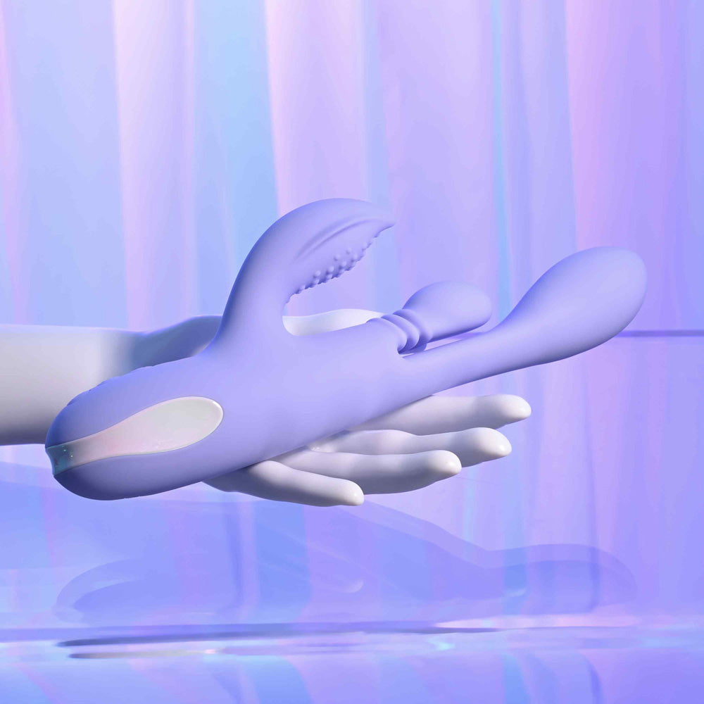 A purple dual thrusting silicone vibrator held in a hand.