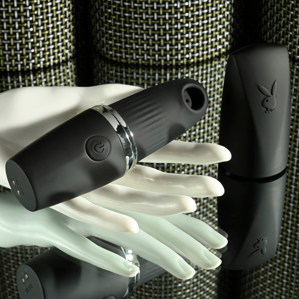 Black Playboy Excursion suction vibrator made of silicone with a power button.