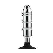 Stainless steel anal plug with a pointed tip, ribbed body, and black suction cup base.