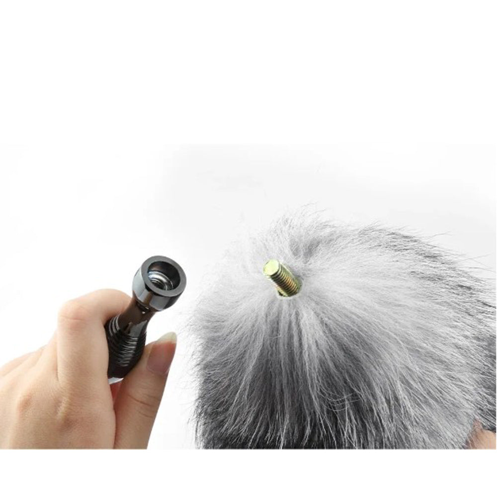 A hand holds a gunmetal base attached to a real fox tail.