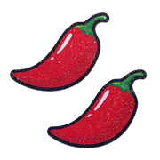 Two red chili pepper nipple pasties with a sparkly texture.