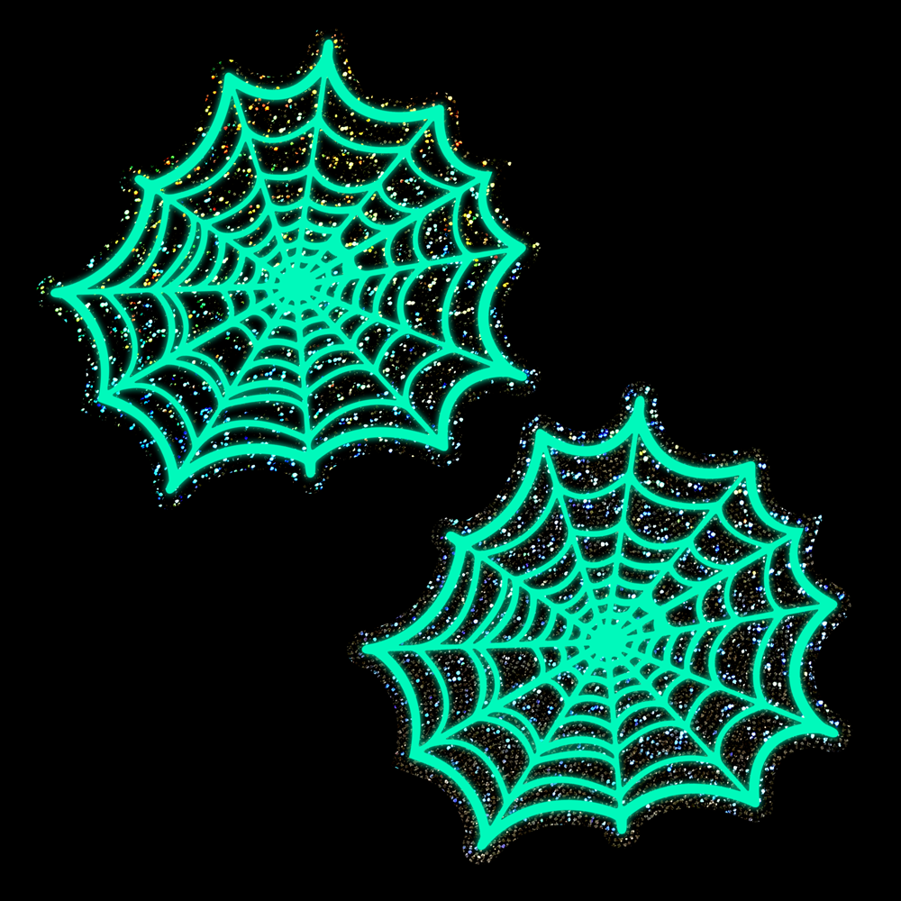 Two glowing green spider web nipple pasties with glitter accents on a black background.