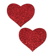 Two red glitter heart pasties on a white background.