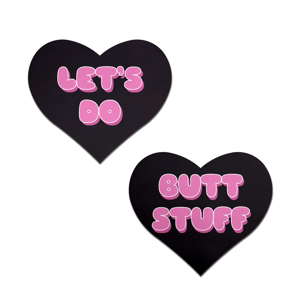 Two black heart-shaped nipple pasties with pink text.