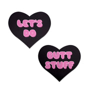 Two black heart-shaped nipple pasties with pink text.