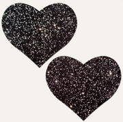 Two black glitter heart-shaped nipple pasties.