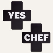 Black cross-shaped nipple covers with "YES" and "CHEF" in white text.