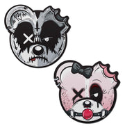 Two zombie bear nipple pasties, one black and white, one pink.