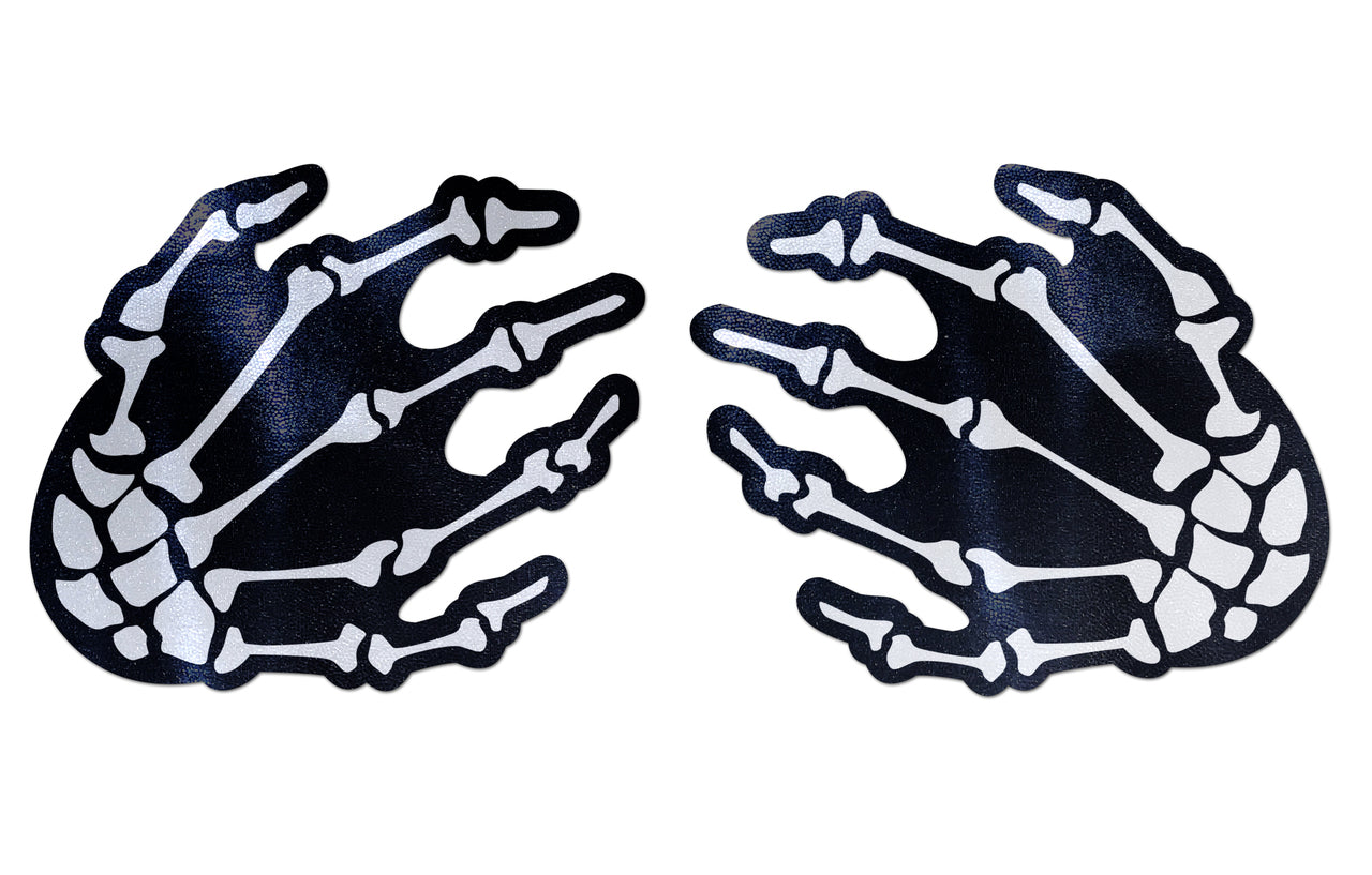 Skeleton hands nipple pasties with white bones on a black background.