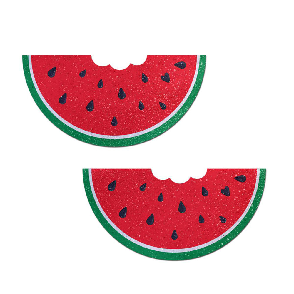Two glitter velvet watermelon slice pasties with a bite.