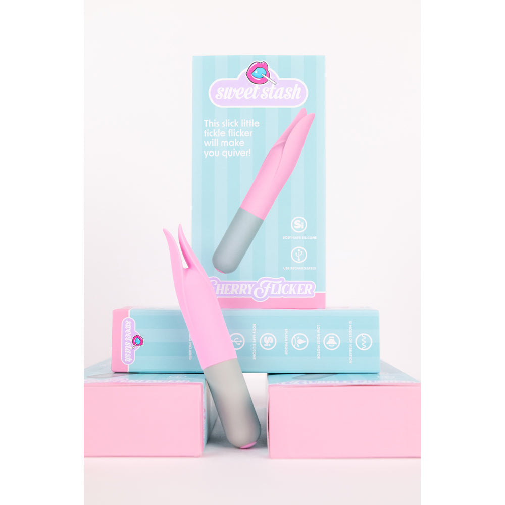 Pink and grey silicone clit tickler with two prongs, on a light blue box.