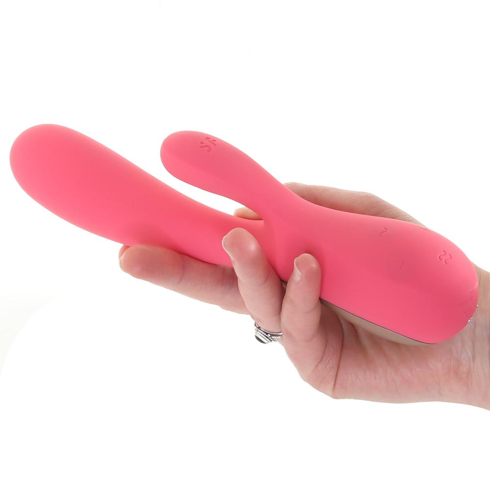 A pink rabbit vibrator held in a hand with a ring on one finger.