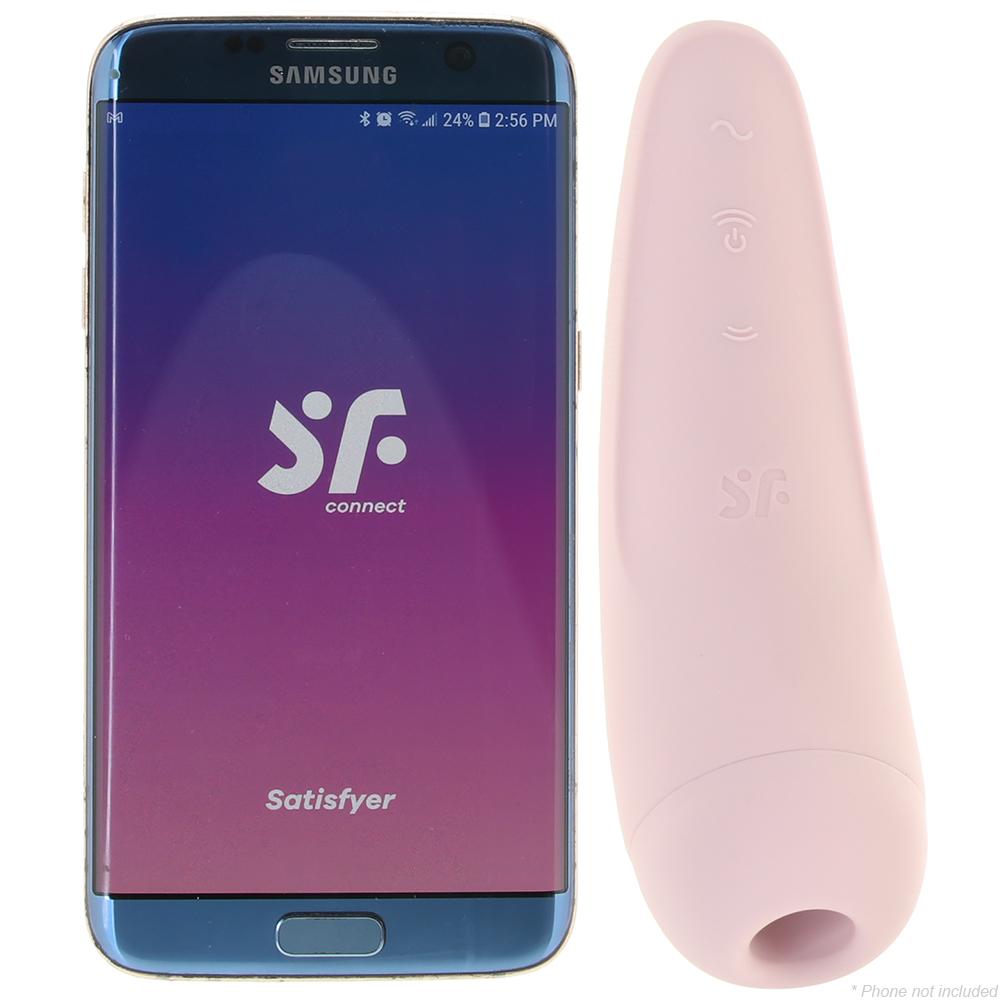 Pink app-controlled air-pulse vibrator next to a smartphone displaying the Satisfyer Connect app.