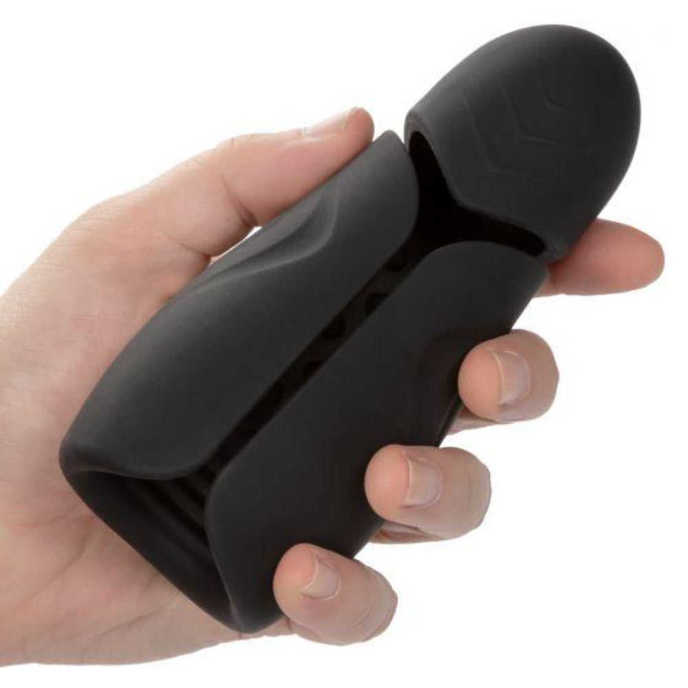 Black vibrating masturbator held in a hand.